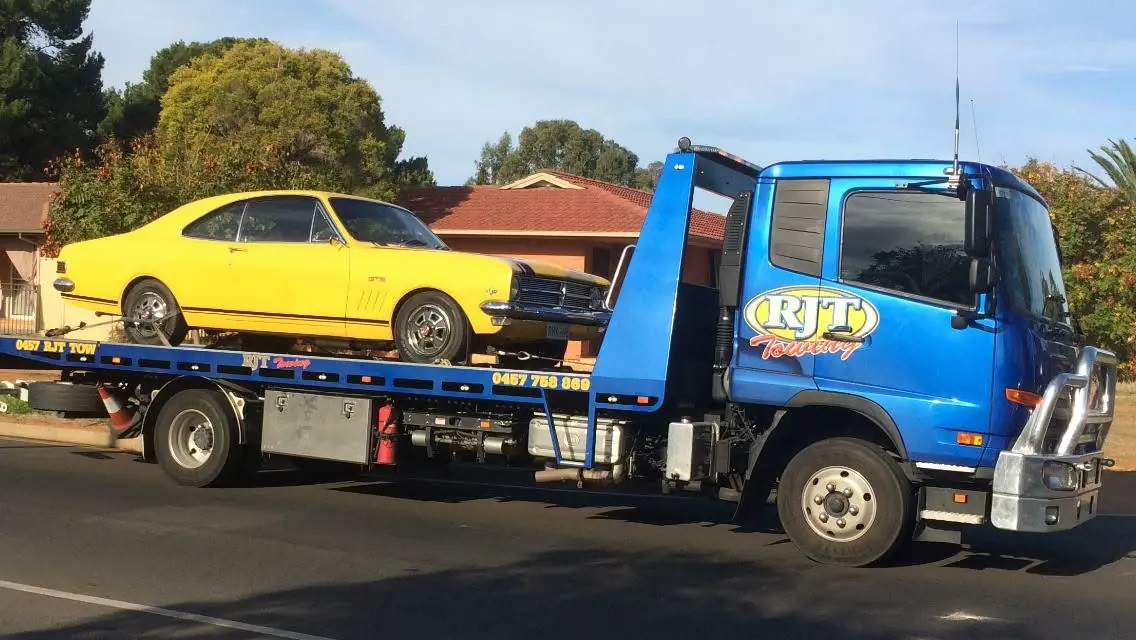 Row of classic cars towed
